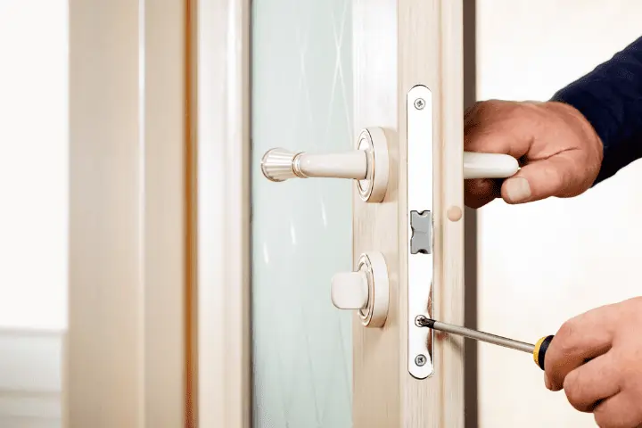 a man is fixing a lock on a commercial door