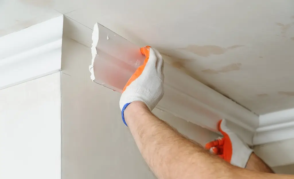 A man is installing a crown moulding
