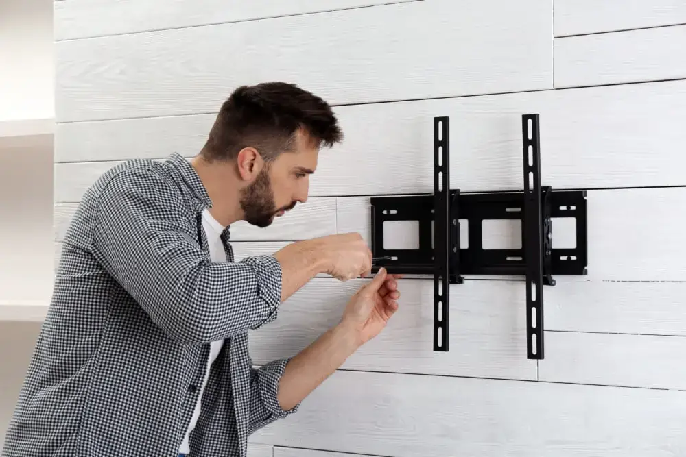 a man is installing a tv mount