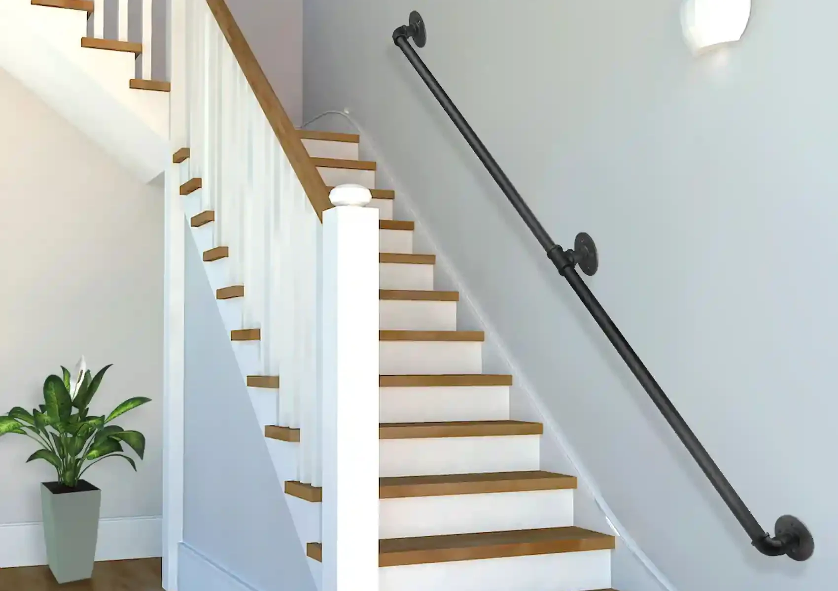 Handrail installation by TJ Handyman Services showing a black wall-mounted railing beside a white staircase with wooden steps in Orlando, FL.