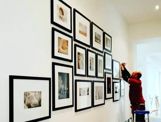 A worker is hanging pictures